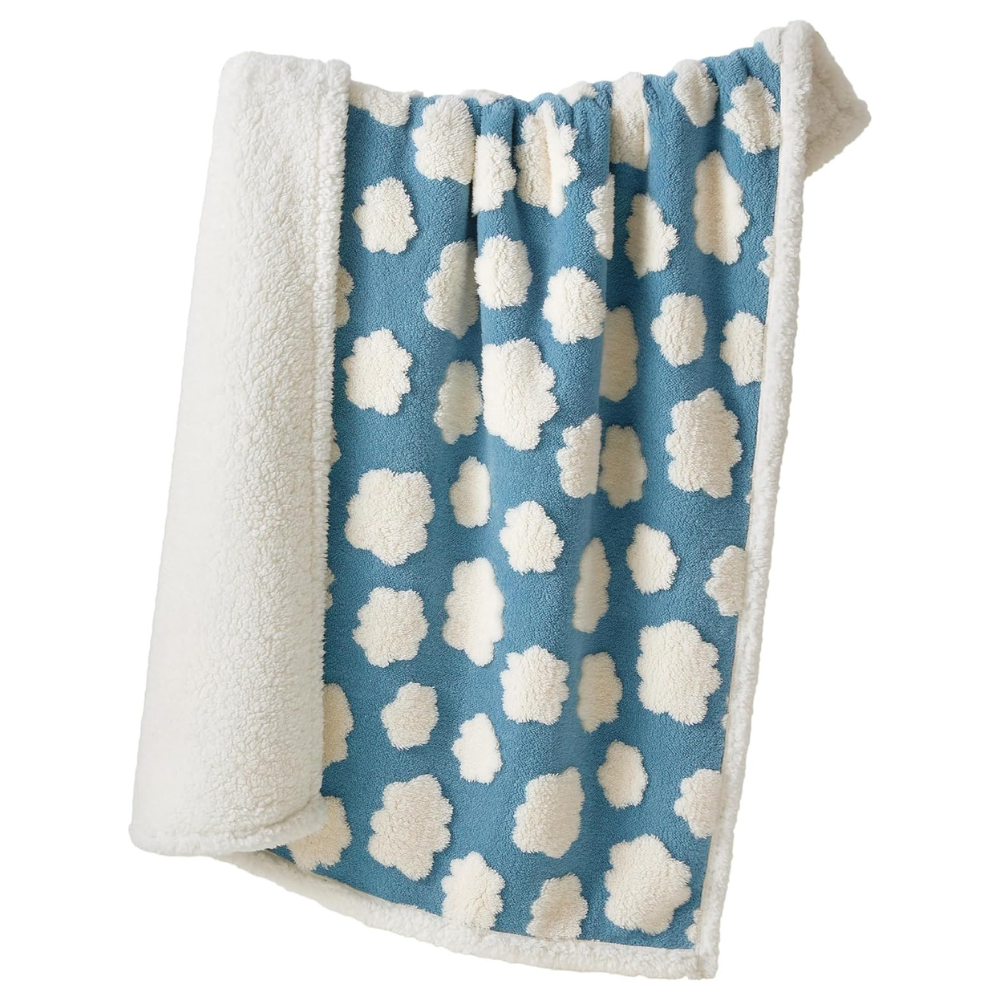 Blue blanket with white cloud pattern and white border on a white background