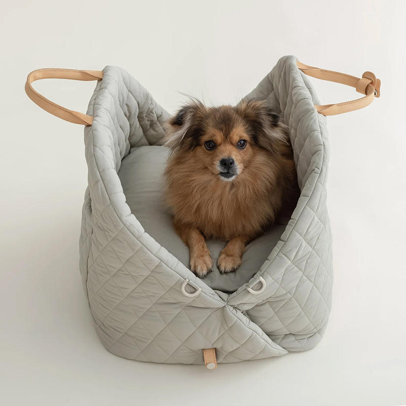 Dog sitting in a quilted pet carrier with wooden handles on a white background